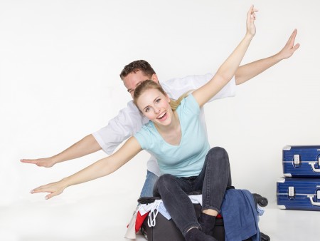 Pareja feliz sobre una maleta juvenil